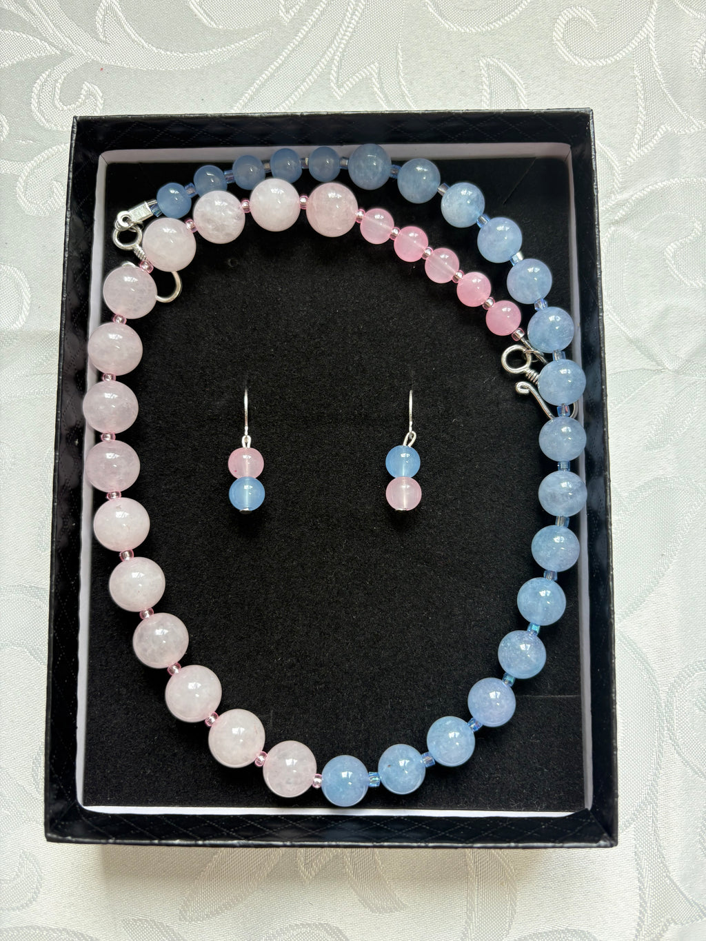 Schmuck-Set aus rosa und hellblauen Edelsteinperlen.