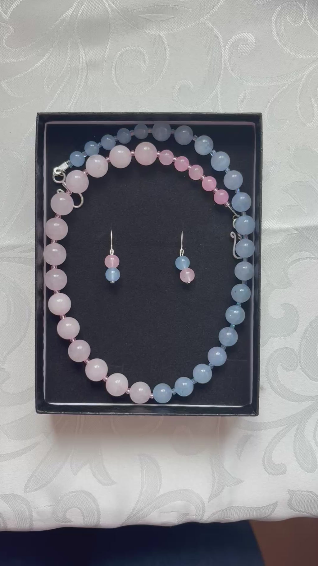 Schmuck-Set aus rosa und hellblauen Edelsteinperlen.